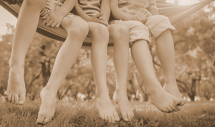 Children with bare feet in hammock